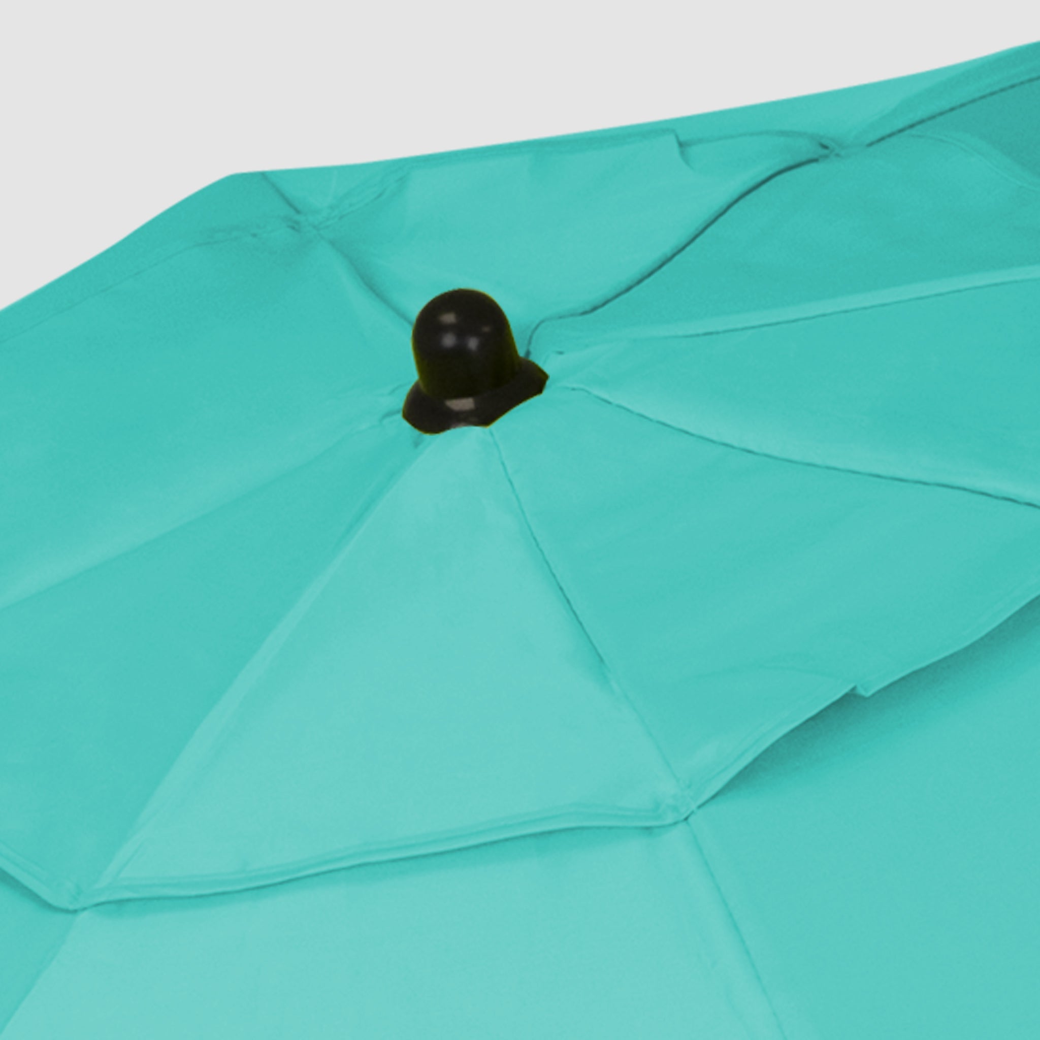 The high-quality, robust Turquoise foldable beach umbrella has a black cap at the top.